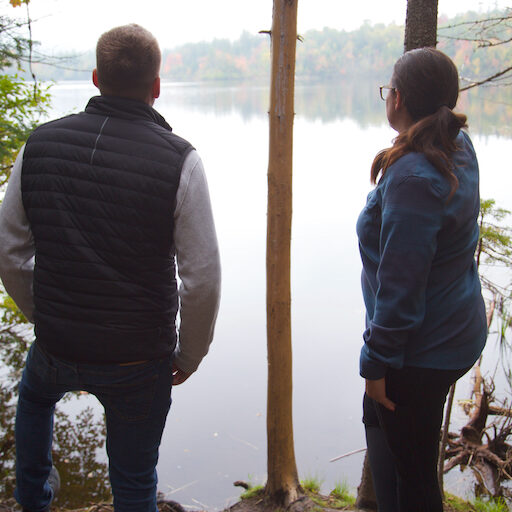 Deux personnes qui admirent un lac lors d'une séance de coaching d'affaires en forêt